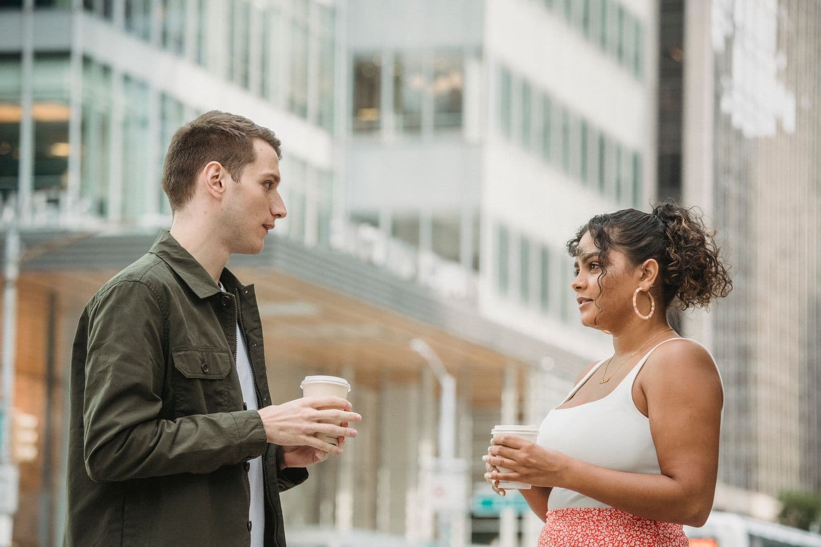 Two people talking one-to-one over coffee outdoors