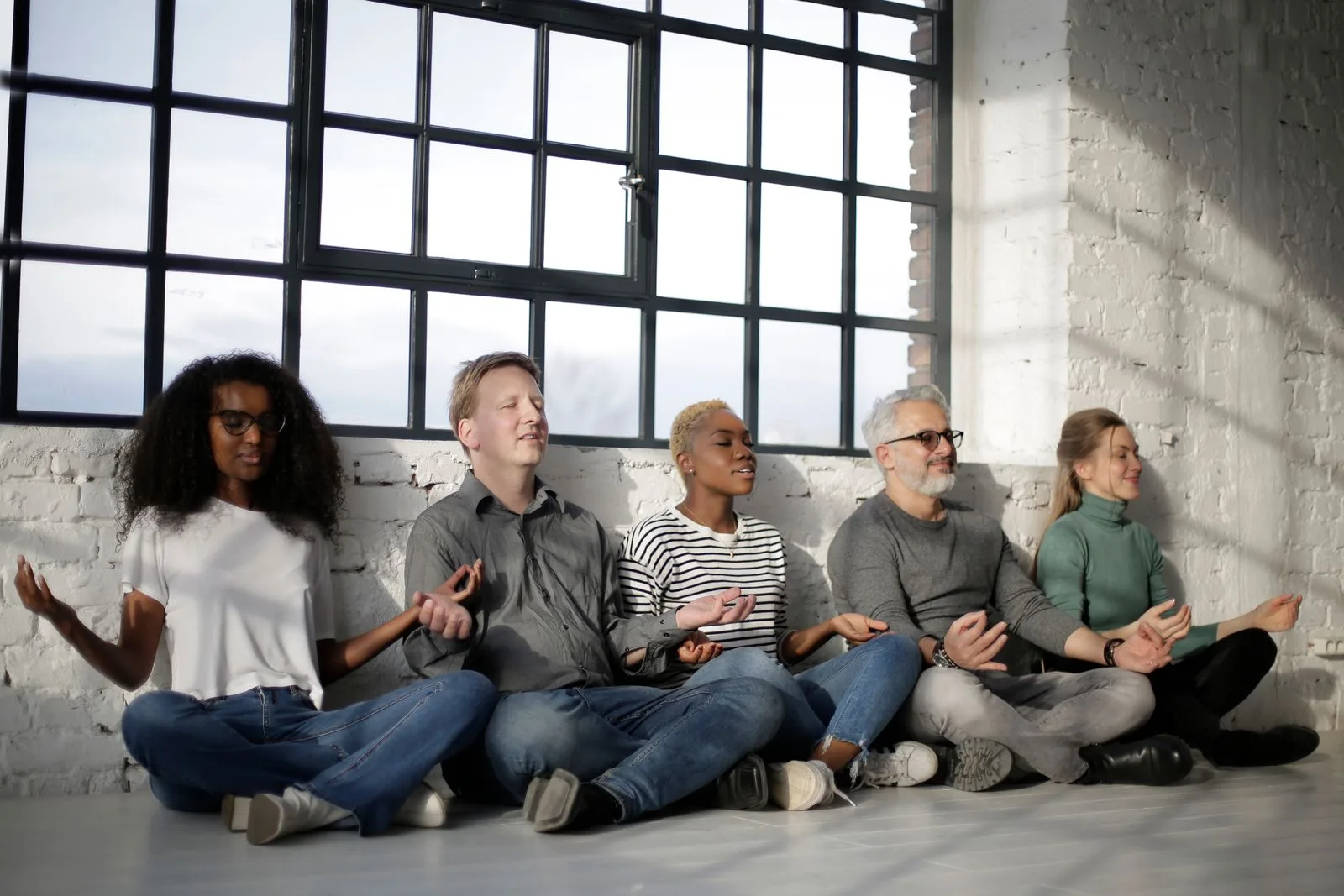 A diverse group sitting calmly together in soft, peaceful light