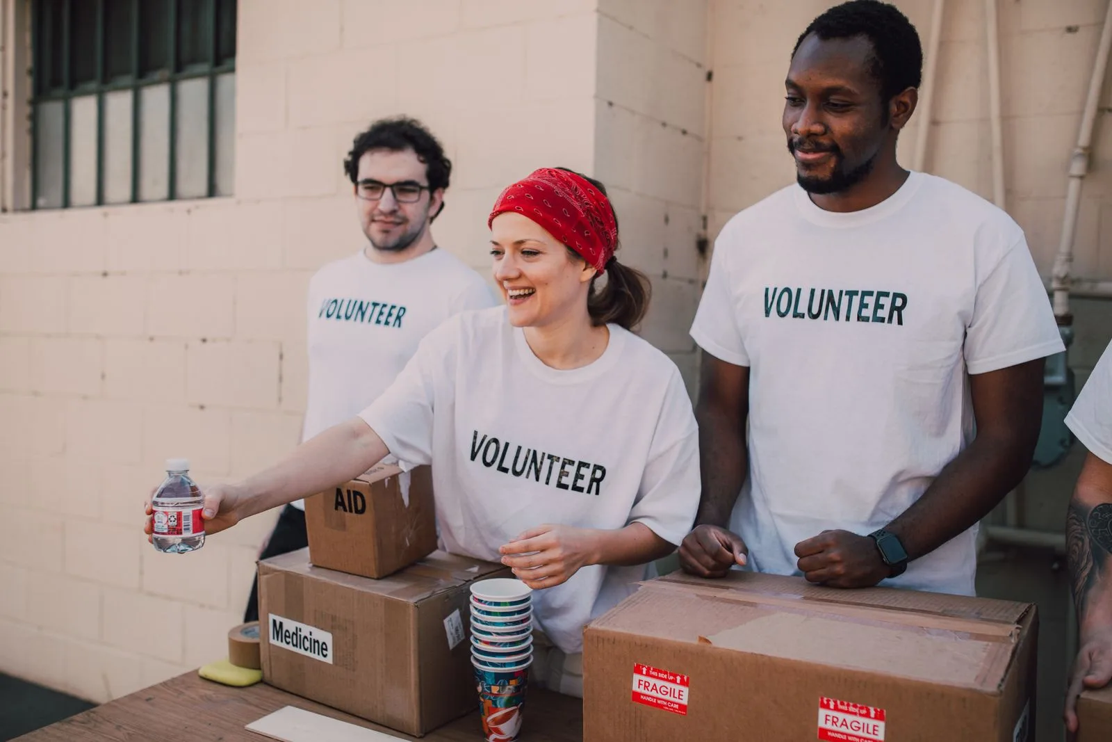 A diverse group of volunteers smiling while helping their community