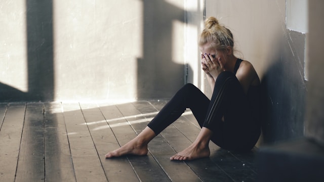 Person sitting alone dealing with breakup and mental health struggles
