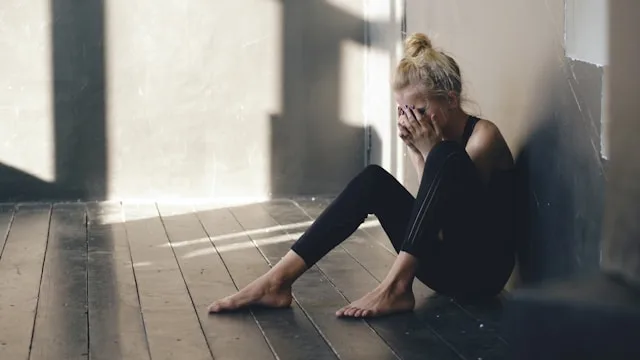 Person sitting alone dealing with breakup and mental health struggles