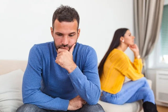 A couple sitting apart and looking away from each other, worn out — the weariness of dating burnout
