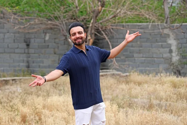 A person standing with arms open in an open field, a picture of emotional openness