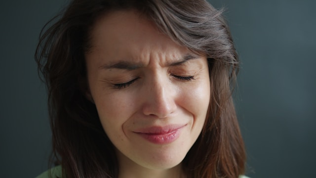 Person sitting alone experiencing emotional pain after breakup and deep sadness