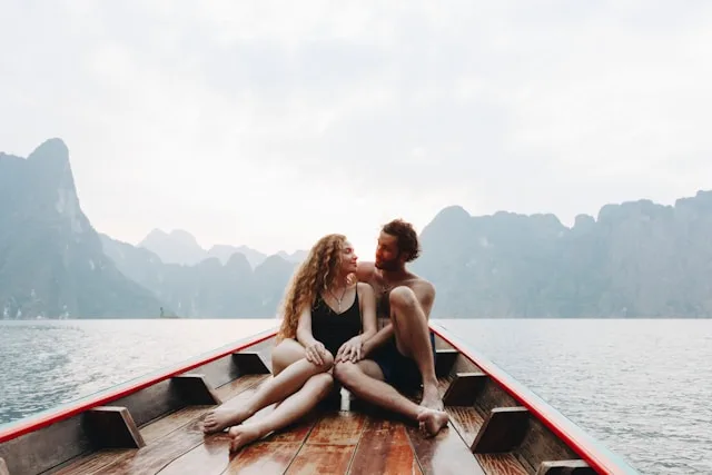A couple sitting close together, smiling and relaxed, sharing an unhurried moment of connection