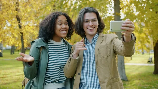 Two adults smiling and connecting together outdoors in a park