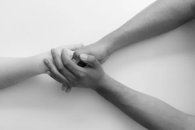 Two hands reaching for and holding each other — a reminder that reconnecting is possible