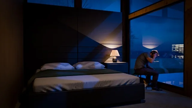 Someone sitting quietly by a window at night — awake, but not as alone as it feels