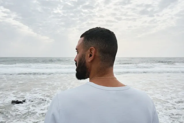 A person looking out at the sea, taking in a major life change