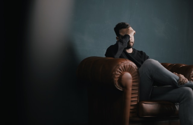 Person experiencing physical symptoms of anxiety such as chest tightness and body tension
